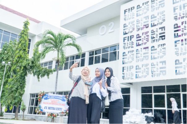 Mahasiswa Fakultas Ilmu Pendidikan (FIP) berswafoto di depan Gedung 02 Pendidikan Guru Sekolah Dasar (PGSD) yang baru saja diresmikan jajaran pimpinan Unesa.