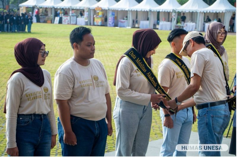 Wakil Rektor 1 Unesa sematkan selempang duta mobilitas akademik kepada perwakilan mahasiswa.