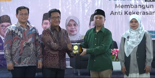 Wakil Rektor Bidang 1 UNESA memberikan cinderamata sebagai penghargaan kepada narasumber Seminar Pendidikan Moderasi Beragama.