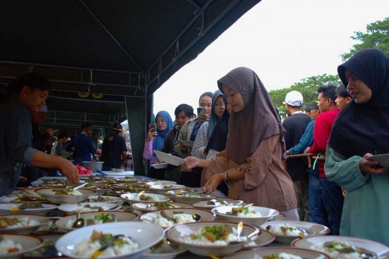 Suasana pembagian takjil gratis dan buka bersama di halaman depan gerbang utama UNESA.