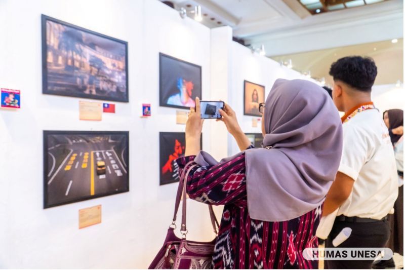 Pengunjung mengabadikan momen di ruang pameran desain internasional Sinestesia di Balai Pemuda Surabaya.